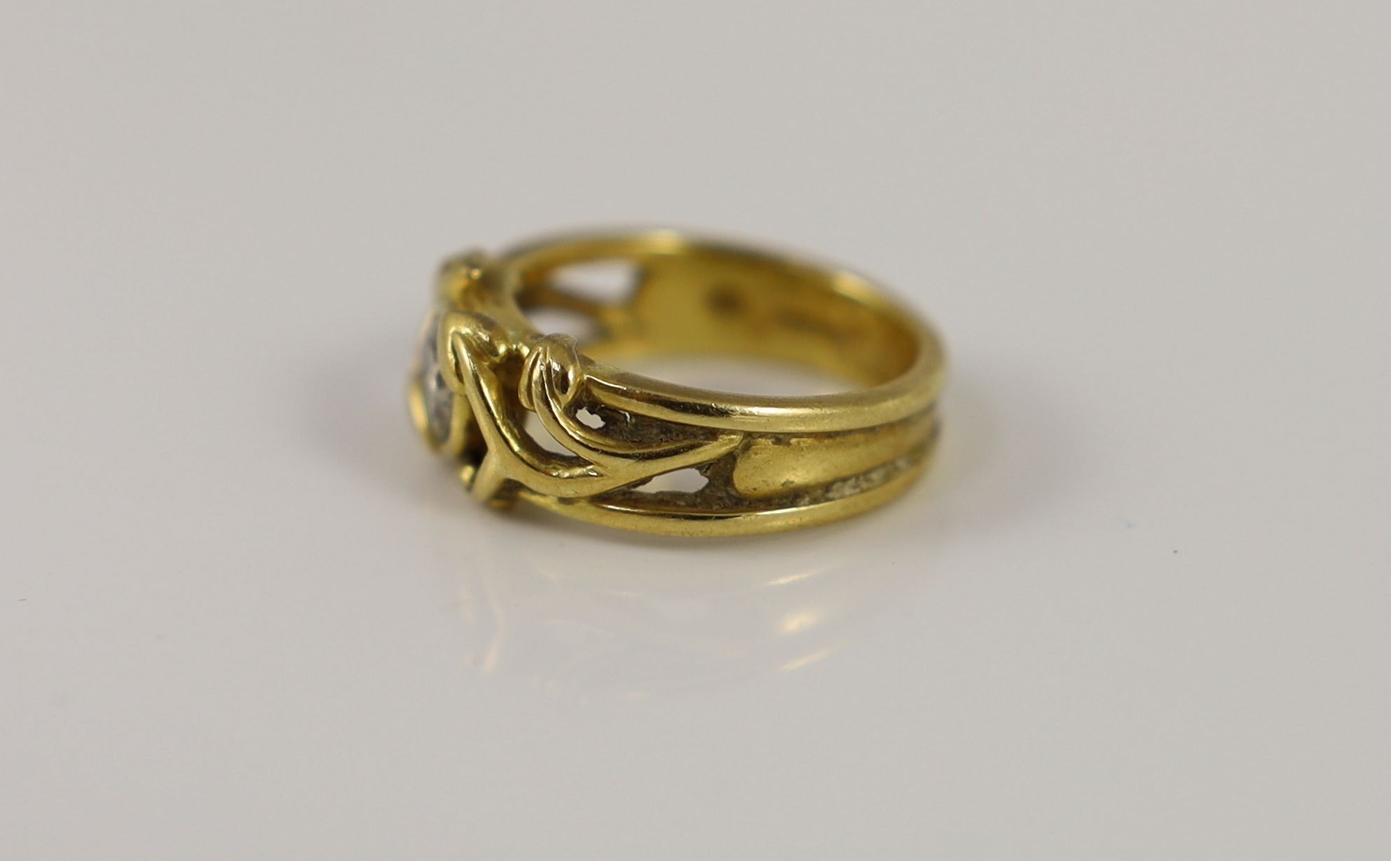 A modern pierced 18ct gold and solitaire diamond set band
